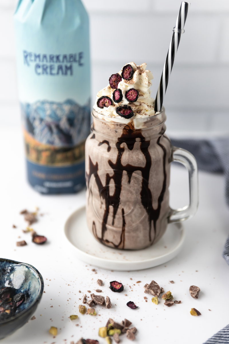 A bottle of Remarkable Cream’s Dark Chocolate Cream Liqueur next to a truly decadent chocolate ice cream dessert drink.